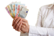Hands offering fan of Euro money bills